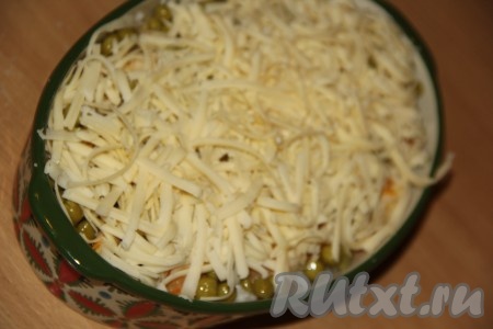 Затем повторить слои: рис, филе с овощами, горошек. Верх будущей запеканки покрыть натёртым сыром.
