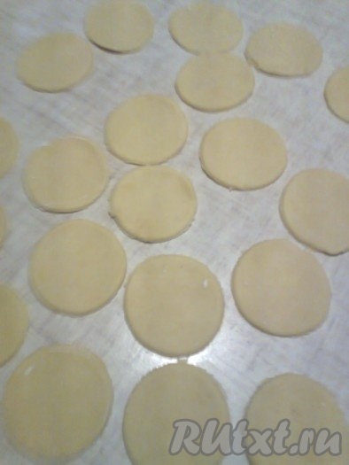 Достать из холодильника песочное тесто, раскатать его в круг толщиной 2 мм (как можно тоньше), вырезать стаканом (или чайной кружкой) круги.
