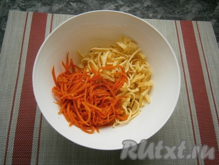 В салат из нарезанных огурцов и копчёной колбасы добавить корейскую морковь и яичные блинчики. Если морковка по-корейски очень длинная, разрежьте её на полоски средней длины.
