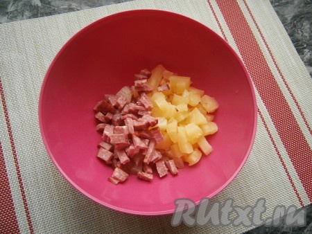Поместить ананас в миску, добавить нарезанную кубиками копчёную колбасу.
