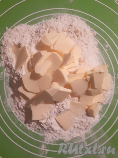 В просеянную муку с сахарной пудрой и солью добавить нарезанное на кусочки сливочное масло и порубить ножом до образования жирных крошек.
