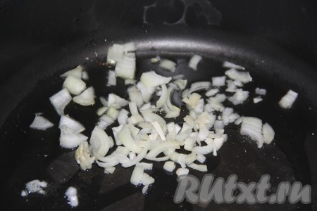 В сковороду влить растительное масло, выложить очищенный и мелко нарезанный лук. Слегка обжарить лук, периодически помешивая.

