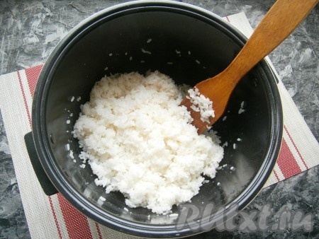 Готовый горячий рис полить подготовленной заправкой и аккуратно, начиная от краев к центру, рис перемешать деревянной (или пластиковой) лопаткой.
