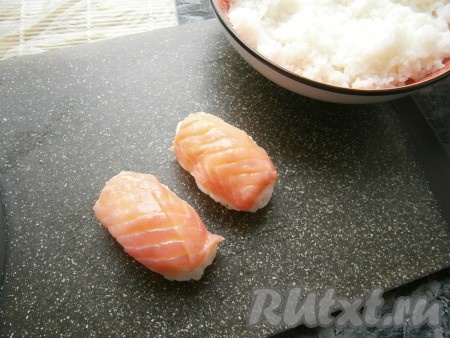 Накрыть каждый брусочек риса кусочком рыбы, прижав её к рису.
