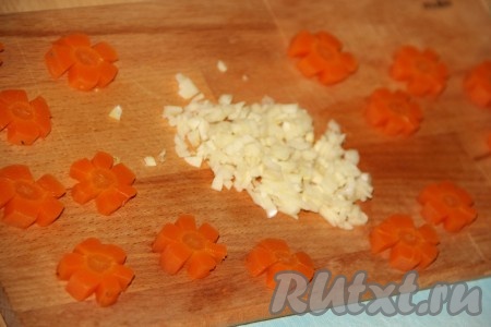 Чеснок мелко нарезать, а из вареной морковки вырезать цветочки.
