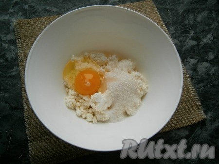 К творогу, который не должен быть сухим, добавить сахар, сырое яйцо, ванильный сахар и соль.
