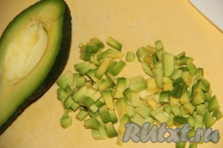 С половины авокадо снять кожуру, предварительно удалив косточку, а затем нарезать на мелкие кубики.
