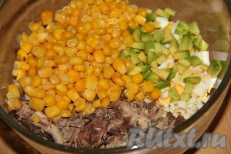 Слить из банки с консервированной кукурузой жидкость, а затем выложить кукурузку в салатник.
