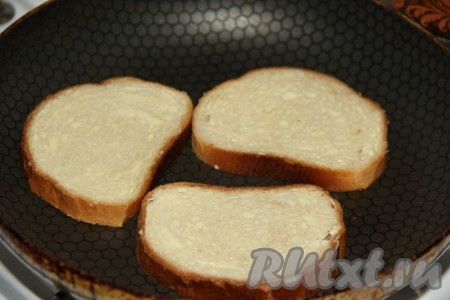Кусочки белого хлеба (или батона) выложить на сковородку и обжарить без добавления масла с двух сторон до золотистого цвета на среднем огне.
