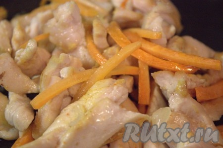 Нарезанную морковку добавить в сковороду к луку и куриному филе, перемешать и обжаривать 3-5 минут, помешивая время от времени.
