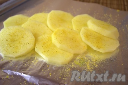 Картофель вымыть, очистить и нарезать тонкими кружочками. Лист фольги слегка смазать растительным маслом и выложить часть кружочков картофеля, посолить, посыпать приправой для картофеля.
