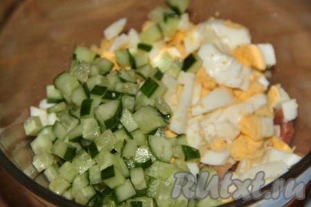 Огурец вымыть, нарезать на мелкие кубики и добавить в салат из красной рыбы и яиц. 