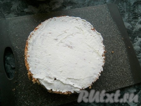 Теперь торт "Искушение" нужно собрать: нижнюю часть бисквита смазать кремом (сразу отложите немного крема и поместите в холодильник, этот крем понадобится в дальнейшем для украшения верха).
