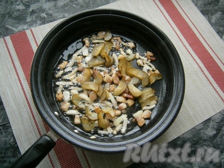 Солёный огурец нарезать тонкими полукружочками и добавить в сковороду. Обжаривать огурчики с луком, помешивая, около 3-4 минут на небольшом огне.

