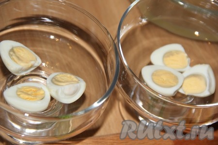 Яйца предварительно сварить (если готовите с перепелиными яйцами, то их нужно отварить в течение 4-5 минут с момента закипания, а куриные яйца нужно варить 10 минут с начала кипения), остудить и очистить. Перепелиные яйца разрезать на две части (куриные яйца нужно будет разрезать на 4 части или на кружочки). Выложить дольки яиц в формы для подачи (или маленькие салатники). Лучше для этого заливного использовать прозрачную посуду, тогда готовое блюдо будет выглядеть более эффектно.
