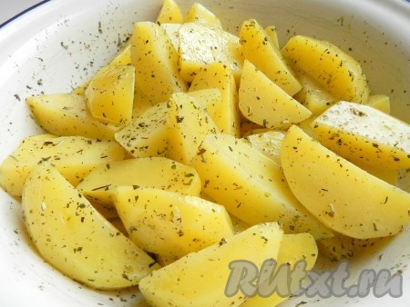 Немного остывший картофель переложить в миску, перемешать со смесью масла и трав и оставить мариноваться на 10 минут.