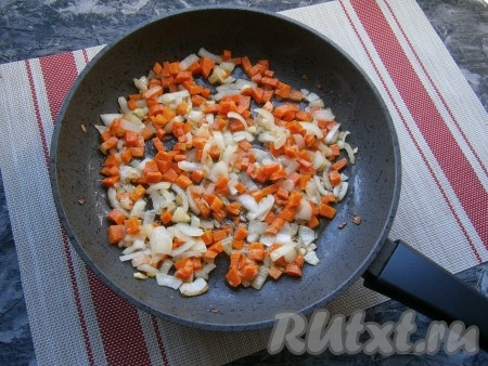 Очищенный репчатый лук нарезать кусочками, очищенную морковь - маленькими кубиками. Обжарить лук с морковкой на сковороде с растительным маслом до мягкости (3-4 минуты) на среднем огне, иногда помешивая.
