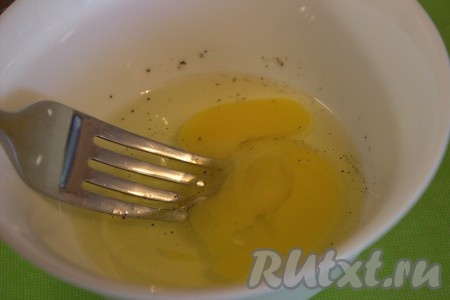 Для приготовления яичного блинчика в миску вбить яйца, посолить, поперчить, а затем при помощи вилки взбить до однородности.
