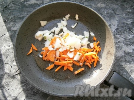 Почистить морковку, чеснок и лук. В сковороду влить растительное масло, выложить нарезанные произвольно лук и морковь.
