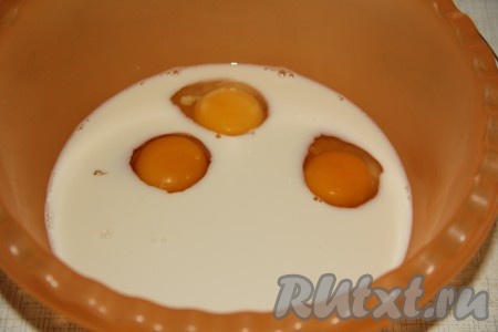 В глубокой миске соединить молоко и воду, перемешать венчиком, затем вбить яйца.
