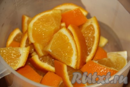 Нарезать апельсины вместе с кожурой на крупные кусочки (косточки удалить) и выложить в чашу блендера.

