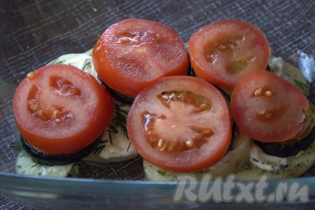 На баклажаны разложить нарезанные кружочками помидоры, сверху посыпать натёртым на мелкой тёрке сыром.
