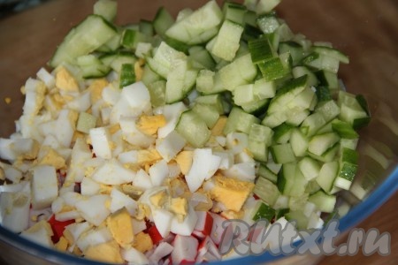 Затем в салат из яиц и крабовых палочек добавить вымытый и нарезанный на средние кубики свежий огурчик.
