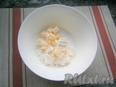 Для приготовления песочного теста насыпать в миску просеянную муку, добавить щепотку соли и нарезанное на кусочки сливочное масло (или маргарин).