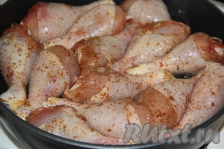 Влить растительное масло в сковороду, поставить на огонь. Замаринованные куриные голени выложить в сковороду.
