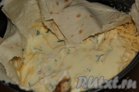 Снова выложить часть кусочков лаваша, замоченных в кефирно-яичной смеси, посыпать частью зелени и сыра. Таким образом, чередуя, выкладывать слои, пока не закончатся сыр и зелень. Вылить сверху оставшуюся кефирно-ячиную смесь с лавашом.