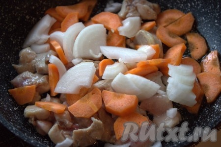 В сковороду к обжаренному куриному филе добавить нарезанные морковь и лук, перемешать, обжарить овощи с мясом на среднем огне, иногда перемешивая, минуты 3-4.
