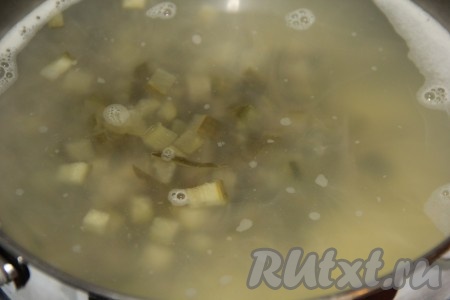 Когда картофель с рисом будут практически готовы, добавить в суп солёные огурцы, дать закипеть и уменьшить огонь.
