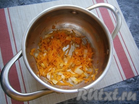 Растительное масло влить в кастрюлю с толстым дном, выложить морковку с луком и обжарить в течение 2-3 минут, помешивая, на среднем огне.
