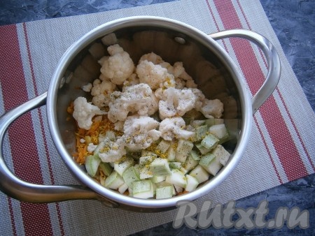 Добавить в кастрюлю кабачки и цветную капусту, всыпать соль, молотый чёрный перец, овощную приправу.
