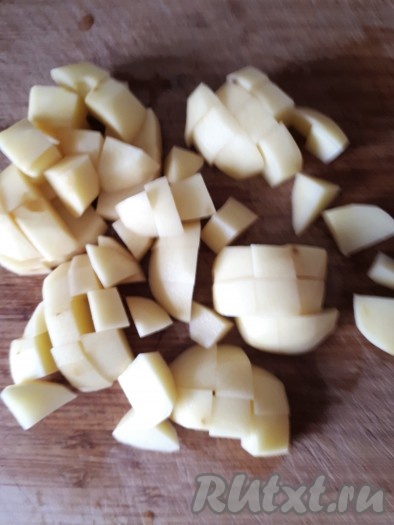 Нарезать кубиками очищенный картофель, выложить в кипящий суп, посолить и поперчить, уменьшить огонь после закипания.
