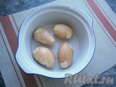 Разместить молодой картофель в кожуре в кастрюльке (или миске), пригодной для СВЧ, влить воду.
