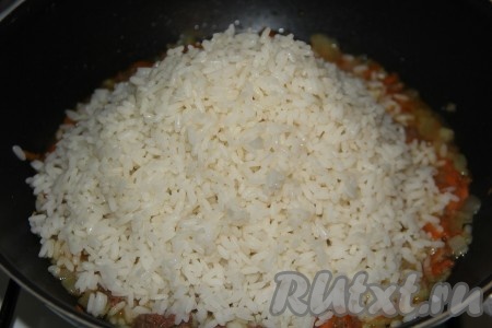 Затем к тушёнке с овощами выложить отваренный рис.

