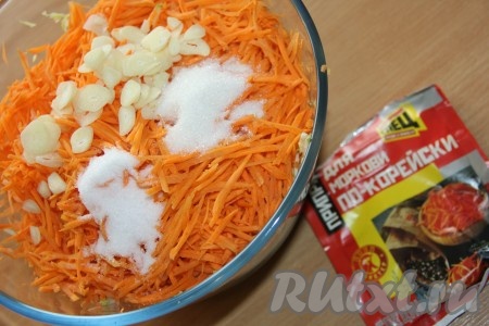 К кабачкам, чесноку и моркови всыпать соль, приправу для корейской моркови и сахар. 