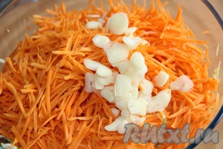 Очищенный чеснок, нарезанный на тонкие лепестки, выложить к кабачкам и моркови.