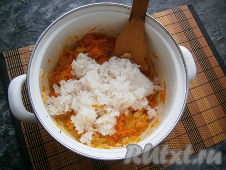 Обжаренную морковку отправить в кастрюлю с луком, перемешать, затем добавить остывший рис.
