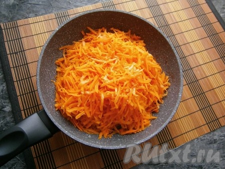 Лук переложить в кастрюлю, в сковороду влить оставшееся масло и выложить натёртую на крупной тёрке морковь.
