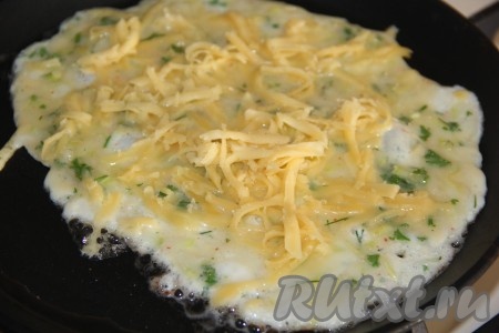 Яично-кабачковую массу посыпать частью натёртого сыра.