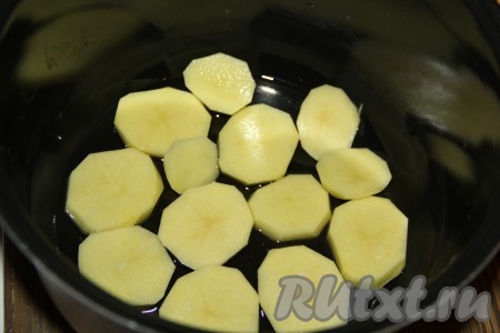 В чашу мультиварки влить растительное масло и выложить часть картофеля (выкладывать нужно в один слой). 