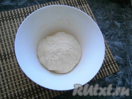 Вначале перемешивая дрожжевое тесто ложкой, а затем вымешивая руками, замесить мягкое, но практически не липкое тесто.
