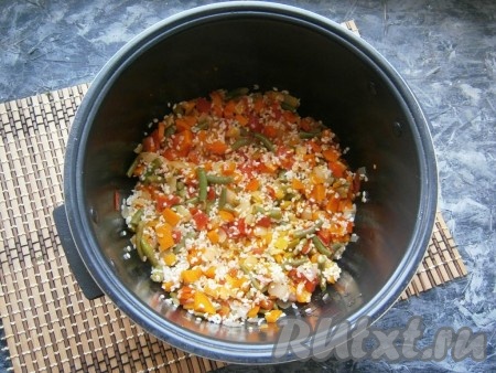 Всыпать подготовленный рис, перемешать его с обжаренными овощами.
