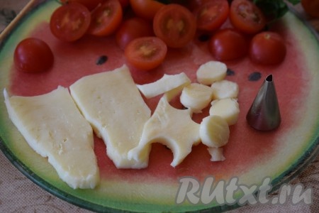 Моцареллу нарезаем на пластины и подходящей формочкой (или насадкой от кулинарного шприца) из сырной пластины вырезаем кружочки, примерно, равные диаметру помидоров. 