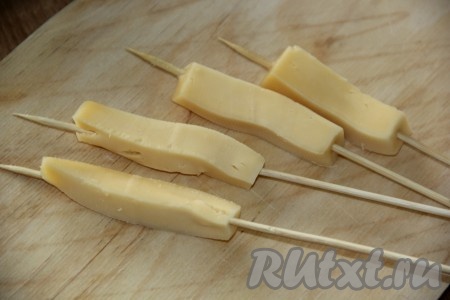 Сыр нарезать на брусочки и наколоть на деревянные шпажки.
