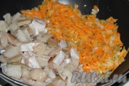 Обжарить морковь с луком в течение 3-5 минут, помешивая, затем добавить кусочки филе минтая.
