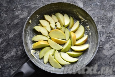 Яблоки очистить от семян, нарезать дольками и разместить их в сковороде в один слой.
