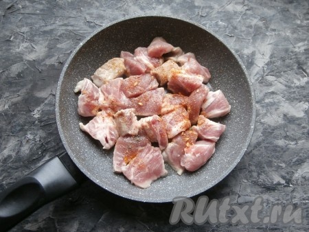 В сковороду, разогретую с растительным маслом, поместить свинину, посыпать специями и солью.